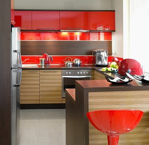 Energetyczna czerwień w towarzystwie drewna to udany sposób na podniesienie atmosfery w kuchni. Intensywny kolor na pewno zwraca uwagę, jednak dzięki oprawie drewna kompozycja z linii KAM Plus nie wydaje się zbyt "krzykliwa".  Fot. KAM